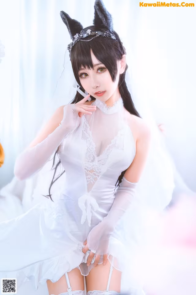 A woman in a white dress and cat ears posing for a picture.