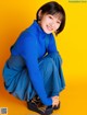 A woman in a blue sweater and blue pants posing for a picture.