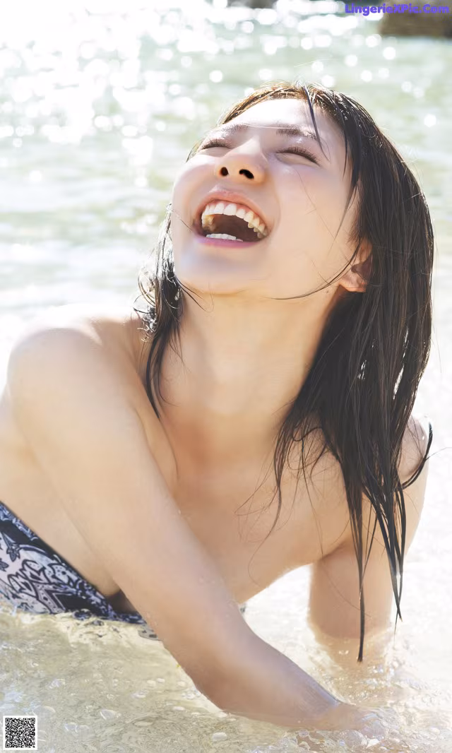A woman in a bikini laying in the water.