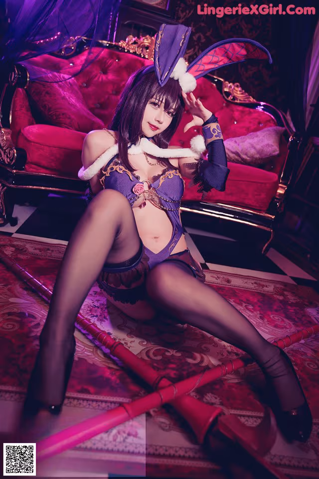 A woman in a bunny costume sitting on a red couch.