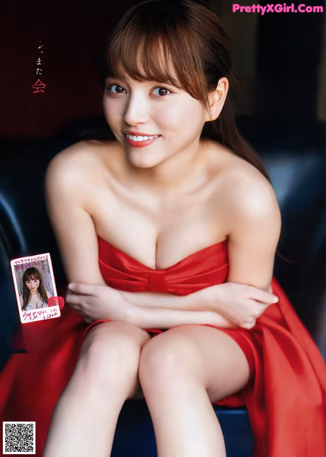 A woman in a red dress sitting on a black chair.