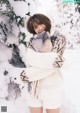 A woman standing in the snow with her arms crossed.