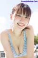 A woman in a blue and white bikini posing for a picture.