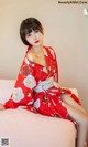 a woman in a red kimono sitting on a bed