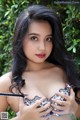 A woman with long black hair wearing a black and white bra.