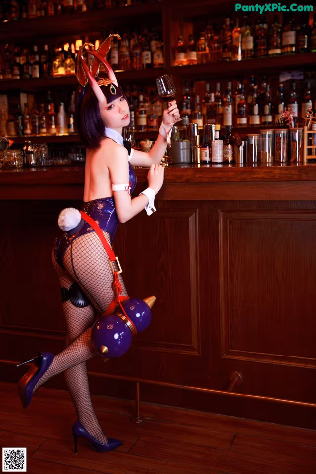 A woman dressed as a devil holding a glass of wine.